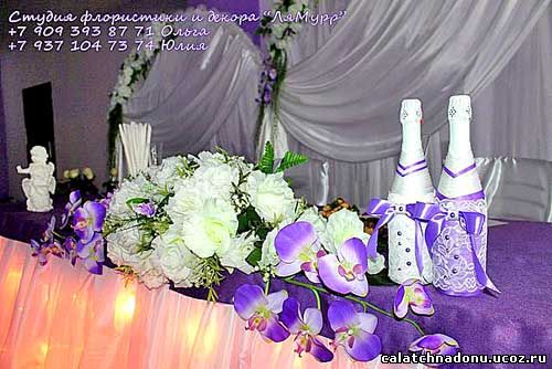 Цветочная композиция и бутылки шампанского на свадебном столе